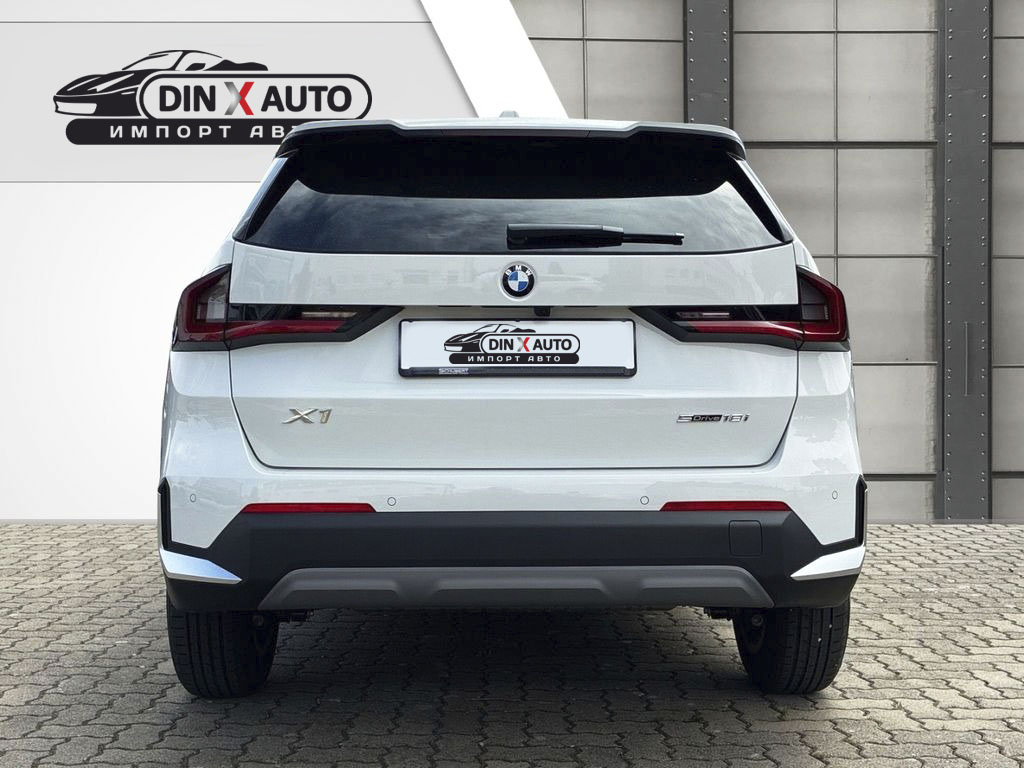 Задняя часть BMW X1 sDrive18i выполнена в фирменном стиле марки — широкие фонари, чёткие линии и акцент на спортивную динамику придают кроссоверу современный и уверенный вид.